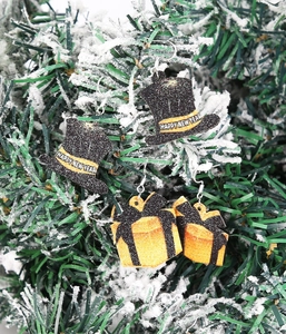 Détail de boucles d'oreilles chapeau Happy New Year et boîte cadeau sur branches enneigées