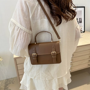 Minimalist brown retro leather crossbody bag with dual golden buckles and adjustable strap