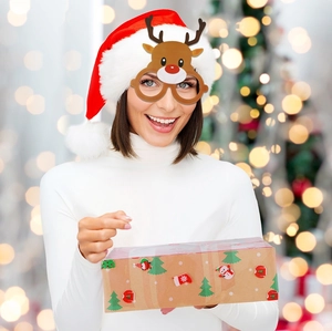 Detail of Christmas reindeer party glasses worn with a Santa hat and festive gift box