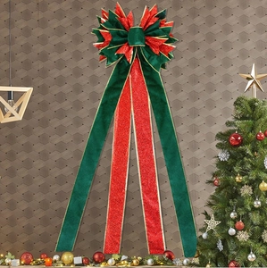 Detail of velvet and gold glitter Christmas bow with dual-tone green and red textures
