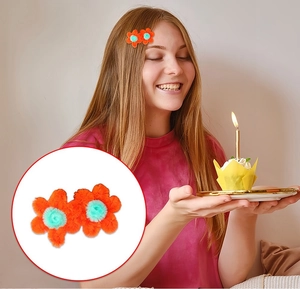 Macro detail of handmade orange and blue plush flower hair clip on a child's hair
