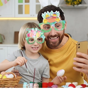 Father and son wearing festive Happy Easter paper glasses with cartoon bunnies and eggs