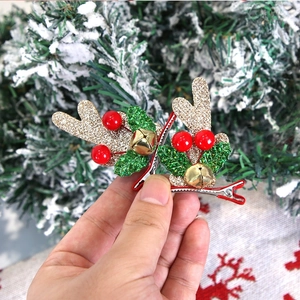 Gros plan de pinces à cheveux bois de renne scintillants avec cloches et décors de Noël