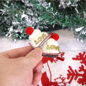 Détail de mini pinces à cheveux bonnet de Noël tricoté avec lettrage LOVE doré
