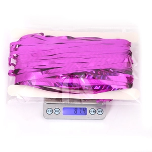 Detailed view of magenta foil fringe curtain 87.4g weight on a digital scale