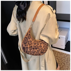 Detailed side view of the leopard print moon bag with brown leather shoulder strap
