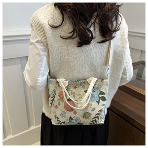 Detailed texture of a floral tapestry crossbody bag with woven vintage pattern