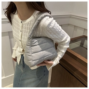 Quilted light gray shoulder bag with soft padded texture and minimalist crossbody style