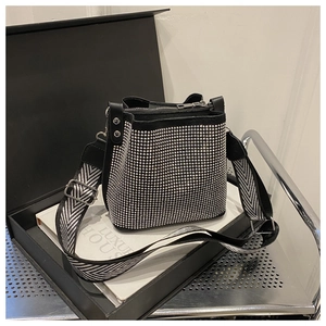 Détail du sac seau noir avec clous argentés et large bandoulière à chevrons