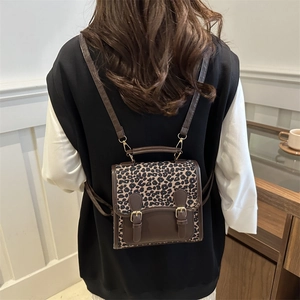 Leopard print mini backpack with brown leather trim and vintage metal buckle closure