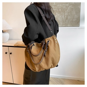 Detail of khaki canvas tote bag with leather handles and adjustable shoulder strap