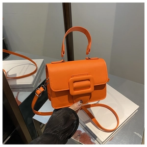 Détail de la texture du cuir PU orange vif et de la fermeture à boucle carrée de sac