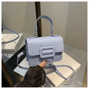 Détail du sac à bandoulière bleu clair avec boucle assortie et texture de cuir fin