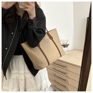 Spacious beige tote bag with brown straps shown in a cozy indoor mirror reflection