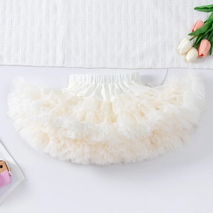 Detailed close-up of cream white tiered mesh tutu skirt with a small silk ribbon bow