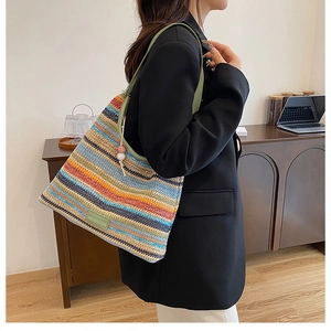 Detailed close-up of colorful striped woven tote bag with green leather strap and beads
