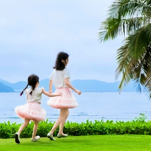 Outdoor shot of mother and daughter in pink layered tutu skirts and white T-shirts
