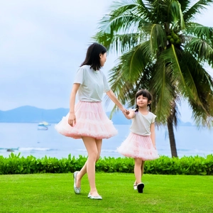 Pink mother and daughter tutu skirts set captured in a sunny coastal outdoor setting