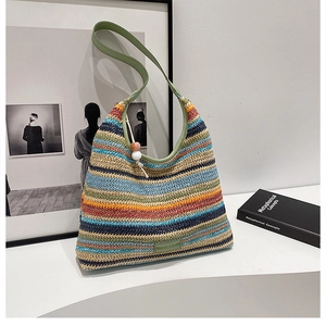 Detail of colorful striped woven tote bag with green leather strap and wooden bead charm