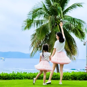Matching pink tulle tutu skirts for mother and child styled with white T-shirts for seaside vacation