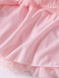 Détail du tissu en maille rose clair et des volants superposés sur une robe tutu