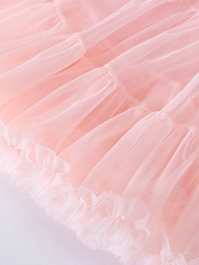 Vue macro du tissu en tulle rose avec volants délicats et détails de texture maille