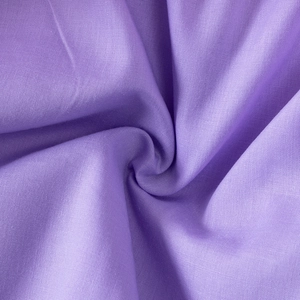 Detailed macro view of soft lavender purple cotton fabric texture with spiral fold