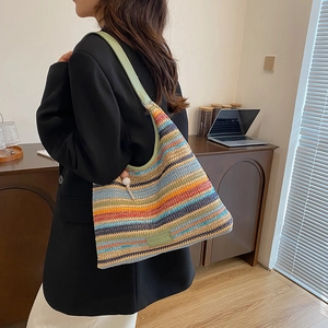 Colorful striped straw shoulder bag with green leather straps for summer vacation