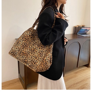 Detailed view of the leopard print canvas tote bag styled on a female model's shoulder