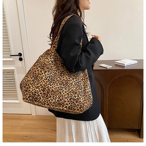 Leopard print canvas tote bag shown on shoulder for high-capacity fashion styling