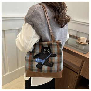 Détail du sac cabas à carreaux avec broderie chat noir et bandoulière en cuir brun