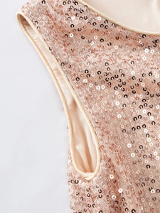 Close-up of champagne gold sequins and smooth silk edge of the children princess dress