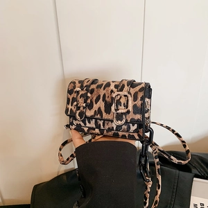 Detail of leopard print shoulder bag with horsehair texture and black buckle accents