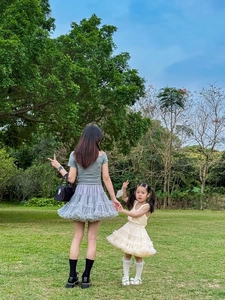 Close-up of cream layered tulle tutu skirt with bow detail on a mother and daughter