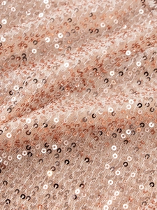 Detailed macro view of sparkling rose gold sequins on delicate mesh fabric for a tutu dress