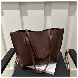 Dettaglio della borsa tote marrone scuro con design patchwork a V e finitura in pelle