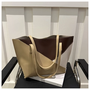 Dettaglio della borsa tote color-block con pannelli in pelle beige e marrone su sedia