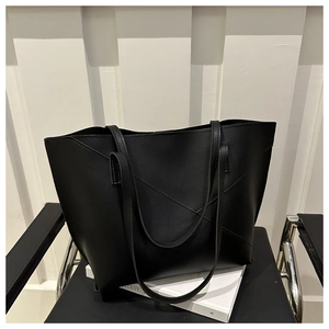 Dettaglio di borsa tote nera minimalista con cuciture a V su ecopelle con finitura opaca