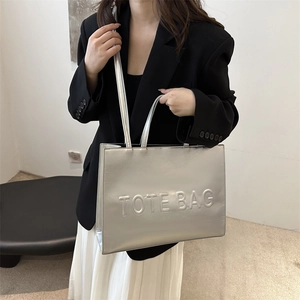 Silver matte oversized tote bag with embossed lettering and long shoulder handles