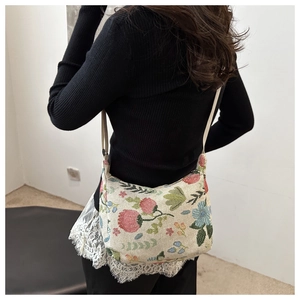 Close-up of vintage floral embroidery and jacquard texture on the canvas crossbody bag