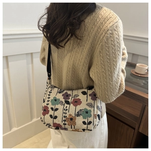 Detail of vintage floral woven shoulder bag with intricate tapestry texture