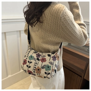 Close-up of floral jacquard hobo bag with a stylish black shoulder strap detail
