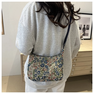 Close-up of vintage floral jacquard texture and silver metal zipper on the shoulder bag