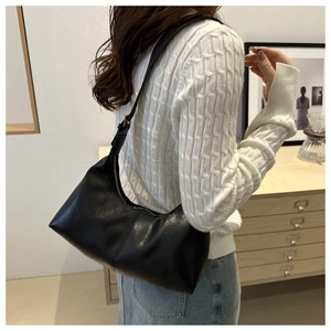 Detailed view of a vintage black leather hobo bag with sleek stitching and adjustable strap