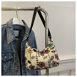Detail of floral tapestry underarm bag with vintage patterns on a metal hanger