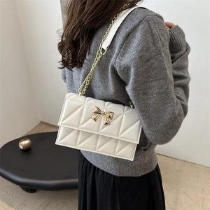 Sac bandoulière matelassé blanc élégant avec boucle nœud doré et chaîne