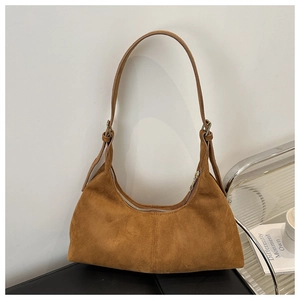 Close-up of brown suede hobo bag detailing the decorative stitching and adjustable strap