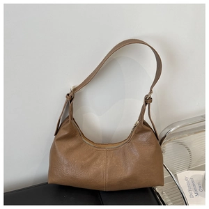 Detail of vintage brown hobo bag showing faux leather texture and adjustable strap buckle
