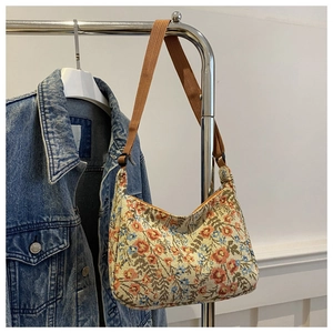 Detailed close-up of vintage floral tapestry bag with adjustable brown woven strap