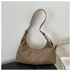 Detail view of a vintage brown hobo bag with textured faux leather and adjustable strap